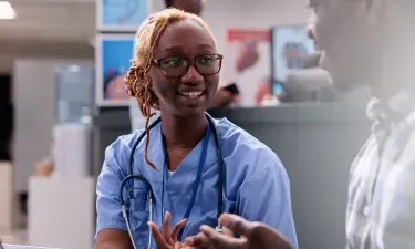 New Jersey medical assistant smiling and discussing treatment with patient in clinic